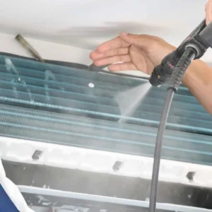 HVAC specialist cleaning an air conditioning coil to improve efficiency and performance.