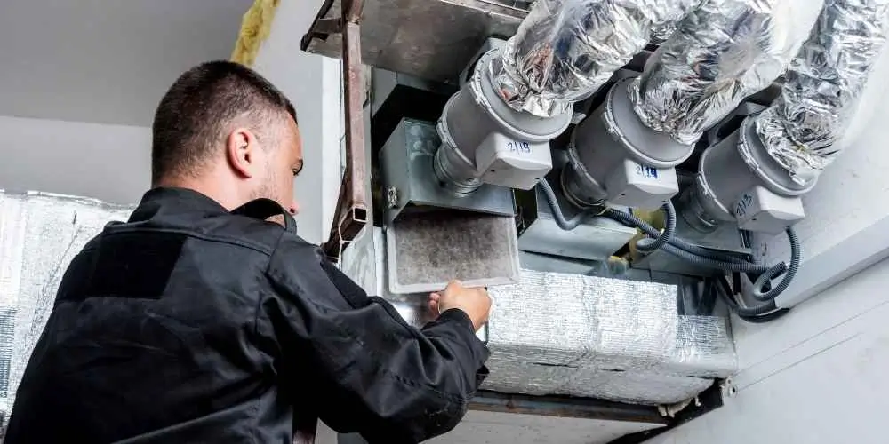 HVAC specialist installing ductwork for efficient heating and cooling system.